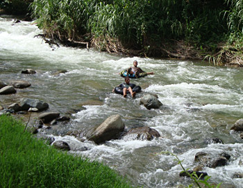Kinder in Gummireifen umschiffen geschickt die Felsbrocken im wilden Wasser. Kinder in Gummireifen umschiffen geschickt die Felsbrocken im wilden Wasser.